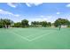 Well-maintained community tennis court on a sunny day, surrounded by mature trees at 12917 Grovehurst Ave, Winter Garden, FL 34787