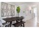 Elegant dining area with modern art and a dark wooden table and bench at 1300 Isleta Loop, Kissimmee, FL 34741