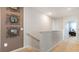 Upstairs hallway with decorative wall art and doorway, offering a bright and welcoming transition space at 1300 Isleta Loop, Kissimmee, FL 34741
