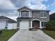 Charming two-story home with a red front door, well-manicured lawn and a private two-car garage at 1321 Carey Glen Cir, Orlando, FL 32824