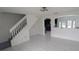 Bright living room featuring white tile floors and stairway access to second floor at 1321 Carey Glen Cir, Orlando, FL 32824