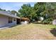 Spacious backyard with a covered patio, lush greenery, and a well-maintained lawn, perfect for outdoor activities at 1324 Saddleridge Dr, Orlando, FL 32835