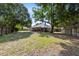 Expansive backyard with mature trees, a patio area, and a wooden fence creating a private outdoor space at 1324 Saddleridge Dr, Orlando, FL 32835