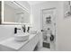 Bright bathroom features double sinks, modern fixtures, a lighted mirror and an attached water closet at 1324 Saddleridge Dr, Orlando, FL 32835