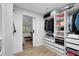 Spacious walk-in closet leads to the bedroom, featuring custom shelving and wood-look floors at 1324 Saddleridge Dr, Orlando, FL 32835