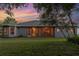 Exterior rear view with a covered, screened-in patio overlooking a lush lawn at 1333 Killbricken Cir, Ormond Beach, FL 32174