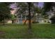 Back of the property featuring a lush green lawn and mature trees at 1333 Killbricken Cir, Ormond Beach, FL 32174