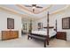 Spacious bedroom with a four-poster bed, tray ceiling, and a large window overlooking the backyard at 1333 Killbricken Cir, Ormond Beach, FL 32174