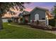 Charming exterior with stone accents and arched windows with a manicured lawn at 1333 Killbricken Cir, Ormond Beach, FL 32174