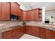 Close up of a kitchen with granite countertops, cherry wood cabinets, stainless steel appliances, and tiled backsplash at 1333 Killbricken Cir, Ormond Beach, FL 32174