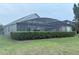 Well-maintained backyard featuring a screened-in patio and manicured hedges at 14400 Saint Georges Hill Dr, Orlando, FL 32828