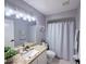 Bright bathroom featuring granite counters, ample lighting, and a shower-tub combo with a shower curtain at 14400 Saint Georges Hill Dr, Orlando, FL 32828