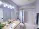 Well-lit bathroom with granite counters, and a shower-tub combo with a stylish curtain at 14400 Saint Georges Hill Dr, Orlando, FL 32828