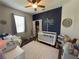 Cozy Bedroom with decorative wall accent, featuring a crib and playful decor at 14400 Saint Georges Hill Dr, Orlando, FL 32828