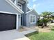 Charming home exterior featuring a well-maintained yard, a dark garage door, and a landscaped entrance at 14400 Saint Georges Hill Dr, Orlando, FL 32828