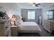A main bedroom that features a ceiling fan, coordinating furniture, wood flooring, and soft, neutral décor at 14400 Saint Georges Hill Dr, Orlando, FL 32828