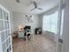 Bright office area with tiled floors, a ceiling fan, a large window, and a desk, offering a versatile workspace at 14400 Saint Georges Hill Dr, Orlando, FL 32828