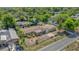 An aerial view shows the home with a large yard, a patio, mature trees, and neighborhood at 1491 Granada Ave, Daytona Beach, FL 32117