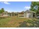 The exterior of this home features a large yard and a covered patio area at 1491 Granada Ave, Daytona Beach, FL 32117