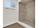 Modern bathroom featuring a tiled shower, neutral walls, and wood-look flooring at 1491 Granada Ave, Daytona Beach, FL 32117