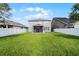 Expansive backyard showcasing a well-kept lawn, white fence, and the rear of the house at 1553 Caterpillar St, St Cloud, FL 34771