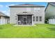 The home's backyard shows a screened patio with the green lawn reaching the back of the home at 1553 Caterpillar St, St Cloud, FL 34771