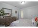 Well-lit bedroom featuring neutral tones, a dresser with a large mirror, and double closet doors at 1553 Caterpillar St, St Cloud, FL 34771