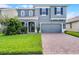 Charming two-story home with a well-manicured lawn and inviting brick driveway at 1553 Caterpillar St, St Cloud, FL 34771