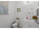 Cozy half bathroom featuring tiled floors, a white sink and vanity, and a window for natural light at 1553 Caterpillar St, St Cloud, FL 34771