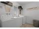 Well-lit laundry room with a washing machine, dryer, sink, and shelving for storage at 1553 Caterpillar St, St Cloud, FL 34771