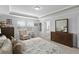 Spacious main bedroom with tray ceilings, carpet flooring, a large bed, and views into the Primary bathroom at 1553 Caterpillar St, St Cloud, FL 34771