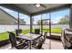 Relaxing screened patio with outdoor seating, offering views of the lush lawn and fenced backyard at 1553 Caterpillar St, St Cloud, FL 34771