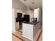 Modern kitchen features white cabinets, black countertops, and stainless steel appliances at 1603 Emily Ct, Kissimmee, FL 34744