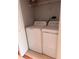A well-lit laundry area with a washer, dryer and built-in storage shelves at 1603 Emily Ct, Kissimmee, FL 34744