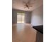 Open living room area with tile flooring, light gray walls, and sliding glass doors to the outside at 1603 Emily Ct, Kissimmee, FL 34744