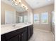 Bathroom featuring a double sink vanity with sleek countertops and a tile shower at 1610 Mohegan Blvd, Kissimmee, FL 34744