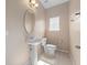 Compact powder room featuring a pedestal sink, toilet, and a neutral color palette at 1610 Mohegan Blvd, Kissimmee, FL 34744
