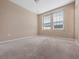 Bedroom with carpet, two sunny windows with blinds, and neutral decor at 1610 Mohegan Blvd, Kissimmee, FL 34744