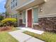 Inviting entryway with red front door, stone accents, and manicured landscaping at 1610 Mohegan Blvd, Kissimmee, FL 34744
