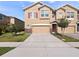 Two story home with a two car garage, stone accents, tan exterior paint and red shutters at 1610 Mohegan Blvd, Kissimmee, FL 34744