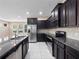 Updated kitchen featuring stainless steel appliances, granite countertops, and dark wood cabinets at 1610 Mohegan Blvd, Kissimmee, FL 34744