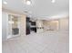 Open living space with tile floors, dark cabinetry in the kitchen, and stairs to upper floor at 1610 Mohegan Blvd, Kissimmee, FL 34744