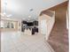 Open-concept living space with tile floors, dark kitchen cabinetry, and staircase at 1610 Mohegan Blvd, Kissimmee, FL 34744