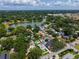 Aerial view of the property, lake, and surrounding neighborhood full of mature trees and landscaping at 1625 S Eola Dr, Orlando, FL 32806