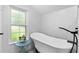 Bright bathroom featuring a sleek bathtub, window, and modern fixtures at 1625 S Eola Dr, Orlando, FL 32806