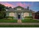 Charming green bungalow at twilight, with an inviting entrance, and manicured landscaping at 1625 S Eola Dr, Orlando, FL 32806