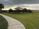 Community playground with shade structure, play equipment and fenced surround at 176 Jensen Dr, Groveland, FL 34736