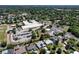 Wide aerial view of residential area with a school and parking lot surrounded by lush greenery at 1821 Windsor Dr, Winter Park, FL 32789
