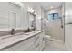 Modern bathroom with double vanity, marble countertops, glass shower, and mosaic tile flooring at 1821 Windsor Dr, Winter Park, FL 32789