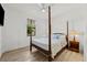 Bedroom with a four poster bed, side tables with lamps, and a large window at 1821 Windsor Dr, Winter Park, FL 32789